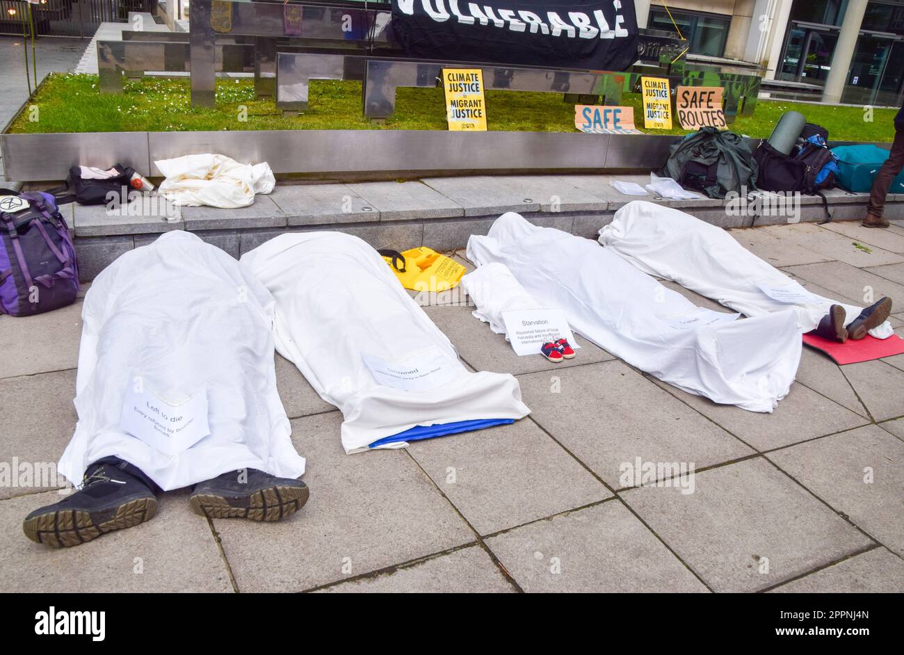 London, UK. 24th April 2023. Activists posing as dead bodies of migrants and people in developing countries affected by climate change lie outside the Home Office on the fourth and final day of Extinction Rebellion's protests in Westminster. Credit: Vuk Valcic/Alamy Live News Stock Photo