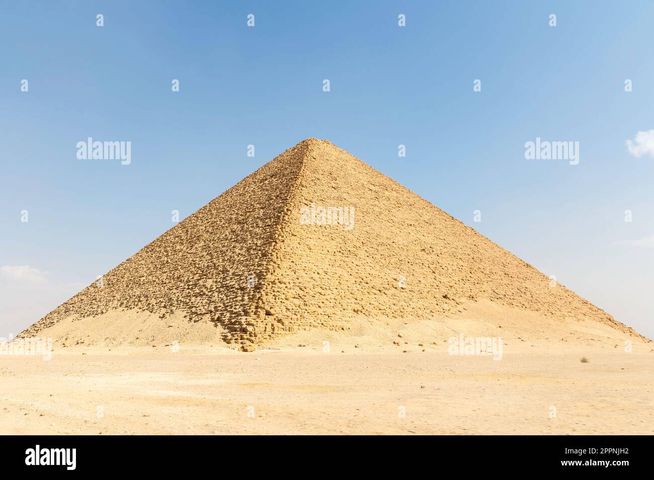 An expansive pyramid structure stands tall in the desert, surrounded by ...
