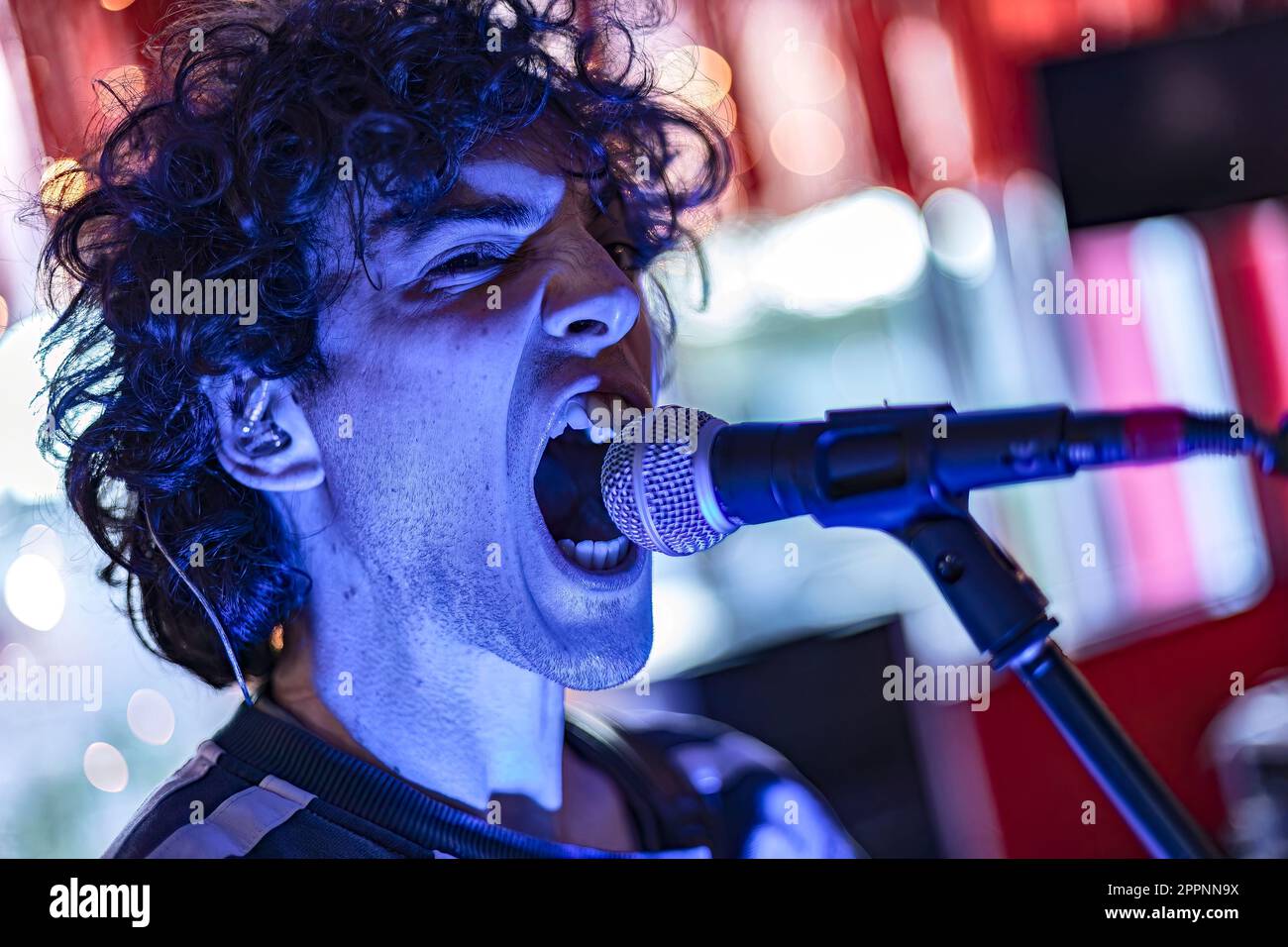 A dynamic photo of a young male singer passionately performing on stage