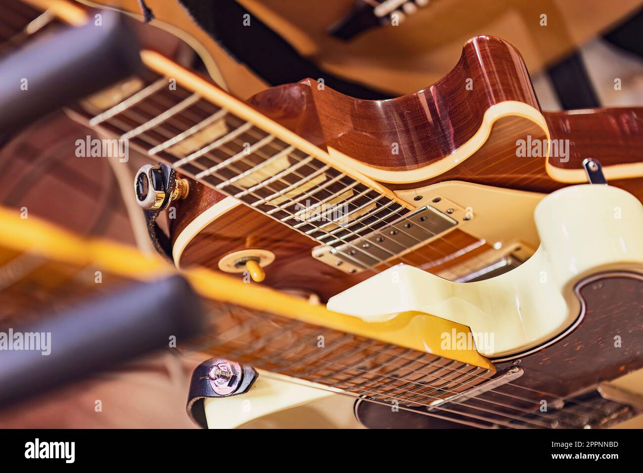 A closeup photo of multiple electric guitars in a row, showing their