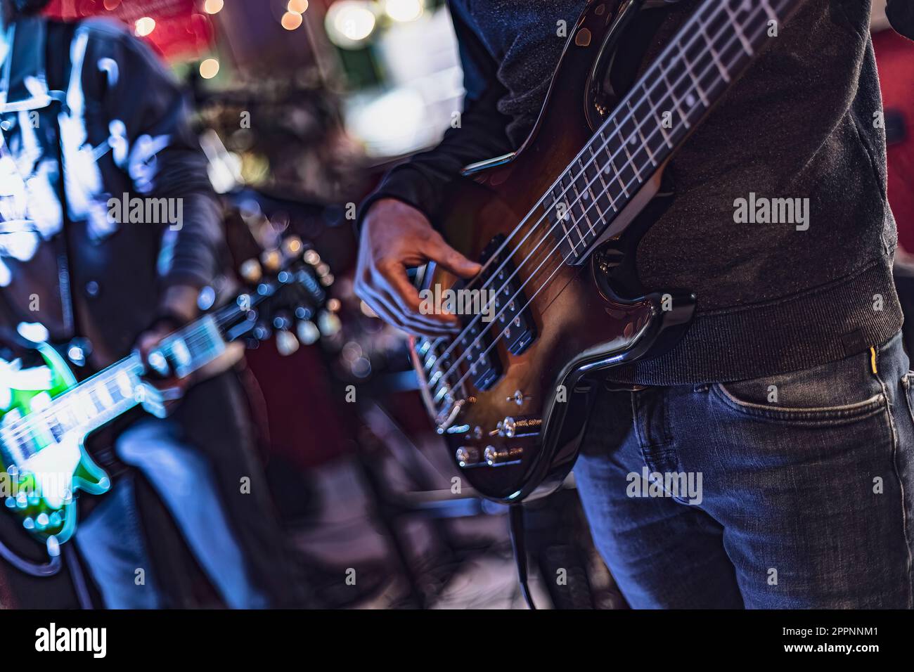 Closeup shot of a bassist's hands playing the bass guitar, fingers