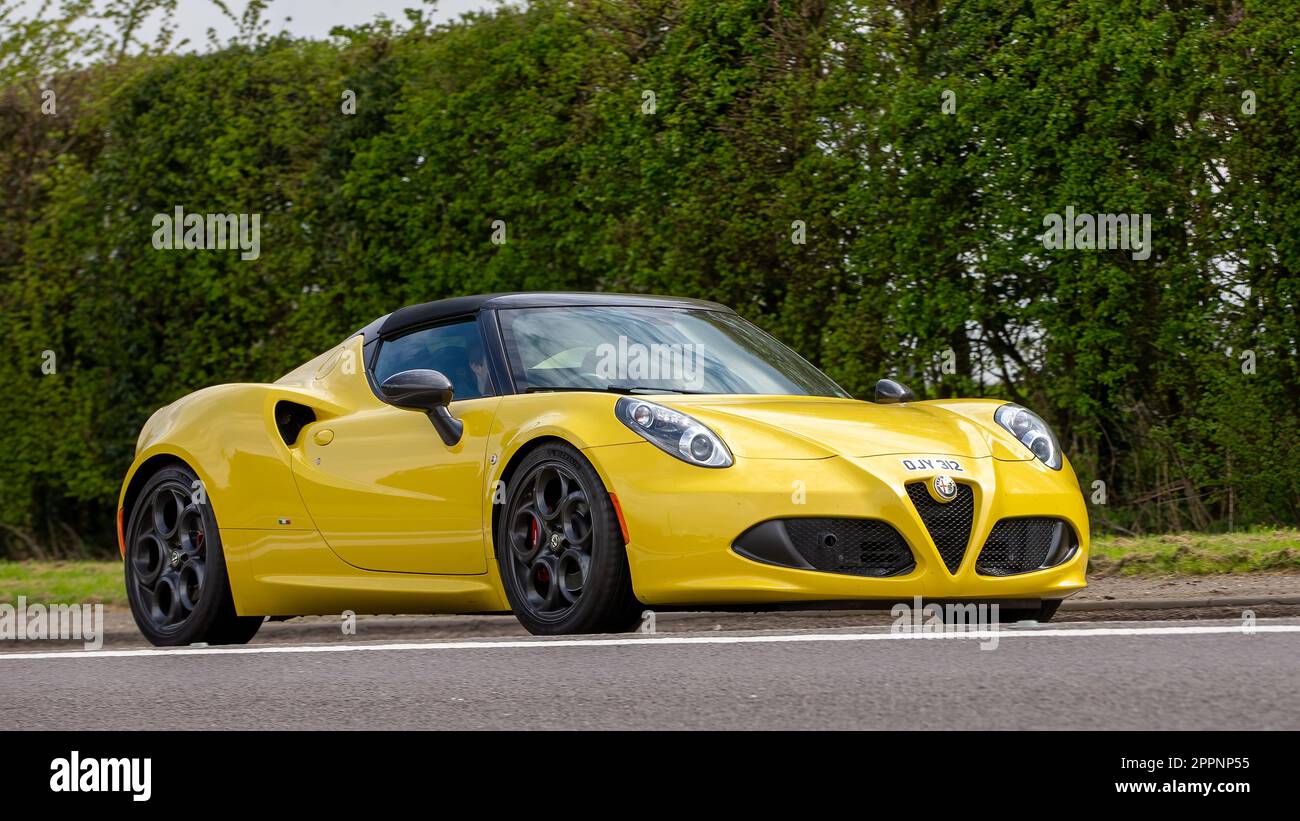 Bicester,Oxon,UK - April 23rd 2023. 2015 yellow Alfa Romeo 4C car travelling on an English country road Stock Photo