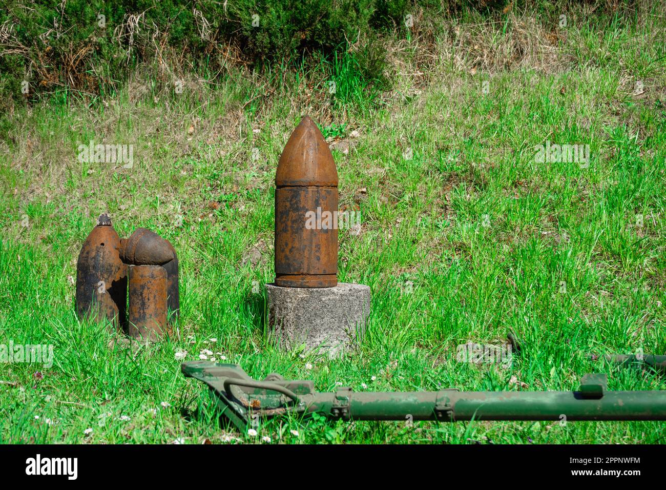 Old rust covered shells for the cannon. Ammunition for an artillery piece on the green grass Stock Photo