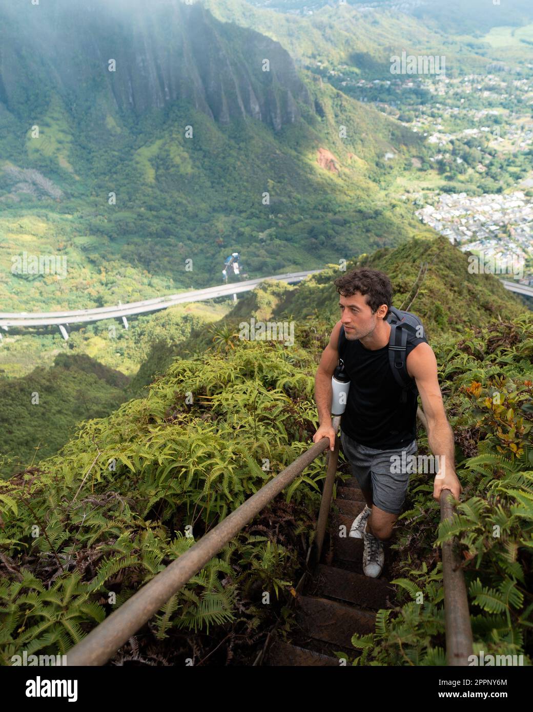 Man Hiking Stairway to Heaven (Haiku Stairs) on Oahu, Hawaii. High quality photo. Looking up the stairs. Stock Photo