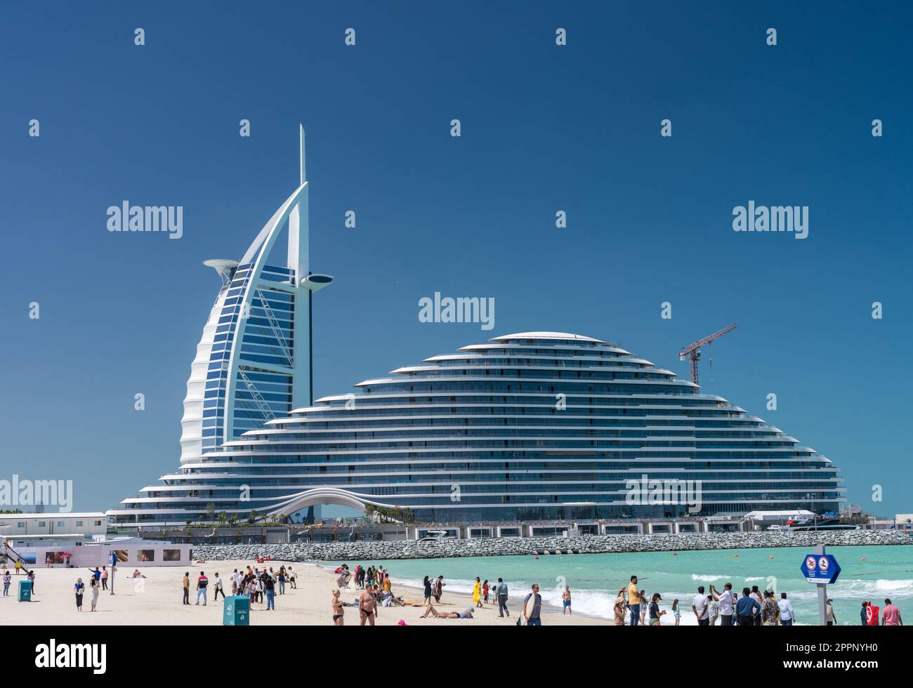 Dubai, UAE - 2 April 2023: Burj al Arab behind Marsa al Arab hotels in Jumeirah from public beach Stock Photo