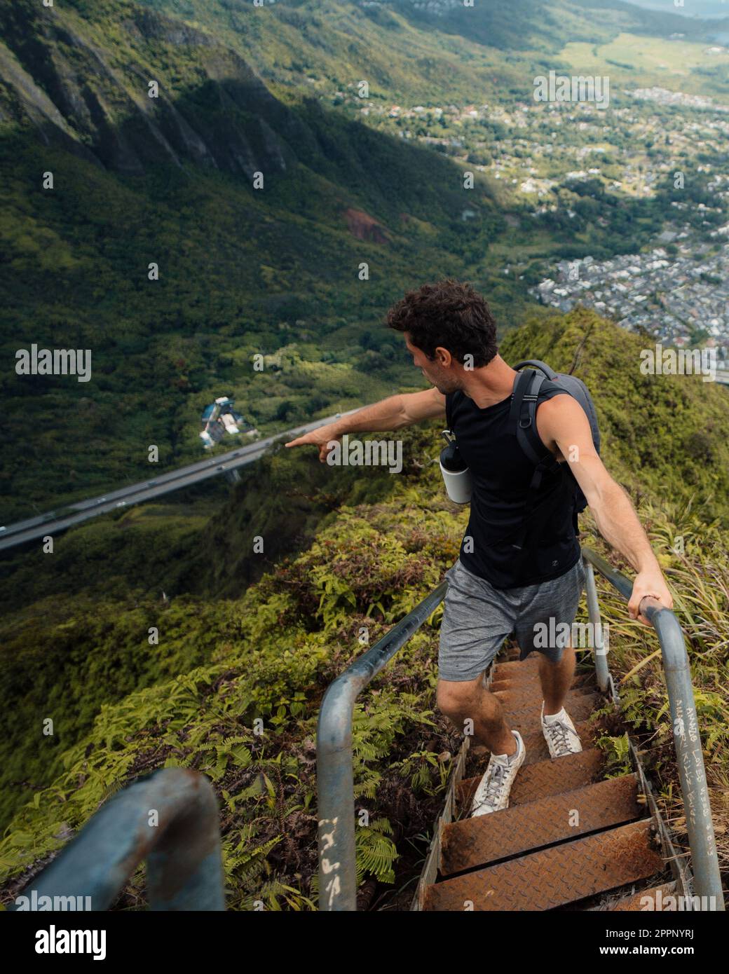 Man Hiking Stairway to Heaven (Haiku Stairs) on Oahu, Hawaii. High quality photo. Looking up the stairs. Stock Photo