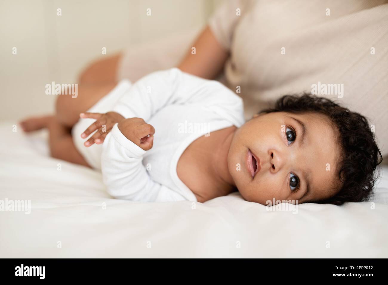 Cute african american small child in white clothes lie sleep on