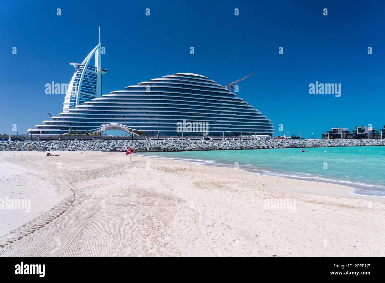 View from Jumeirah public beach of the construction of Marsa al Arab hotel with Burj al Arab behind on coast of Dubai Stock Photo