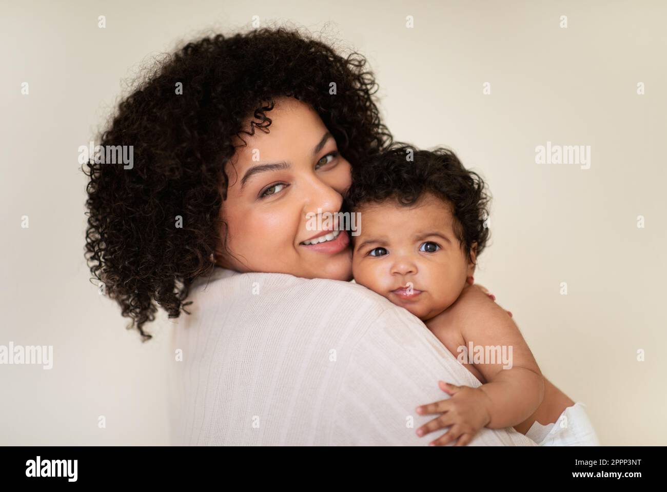 Satisfied millennial african american female hold small baby in diaper