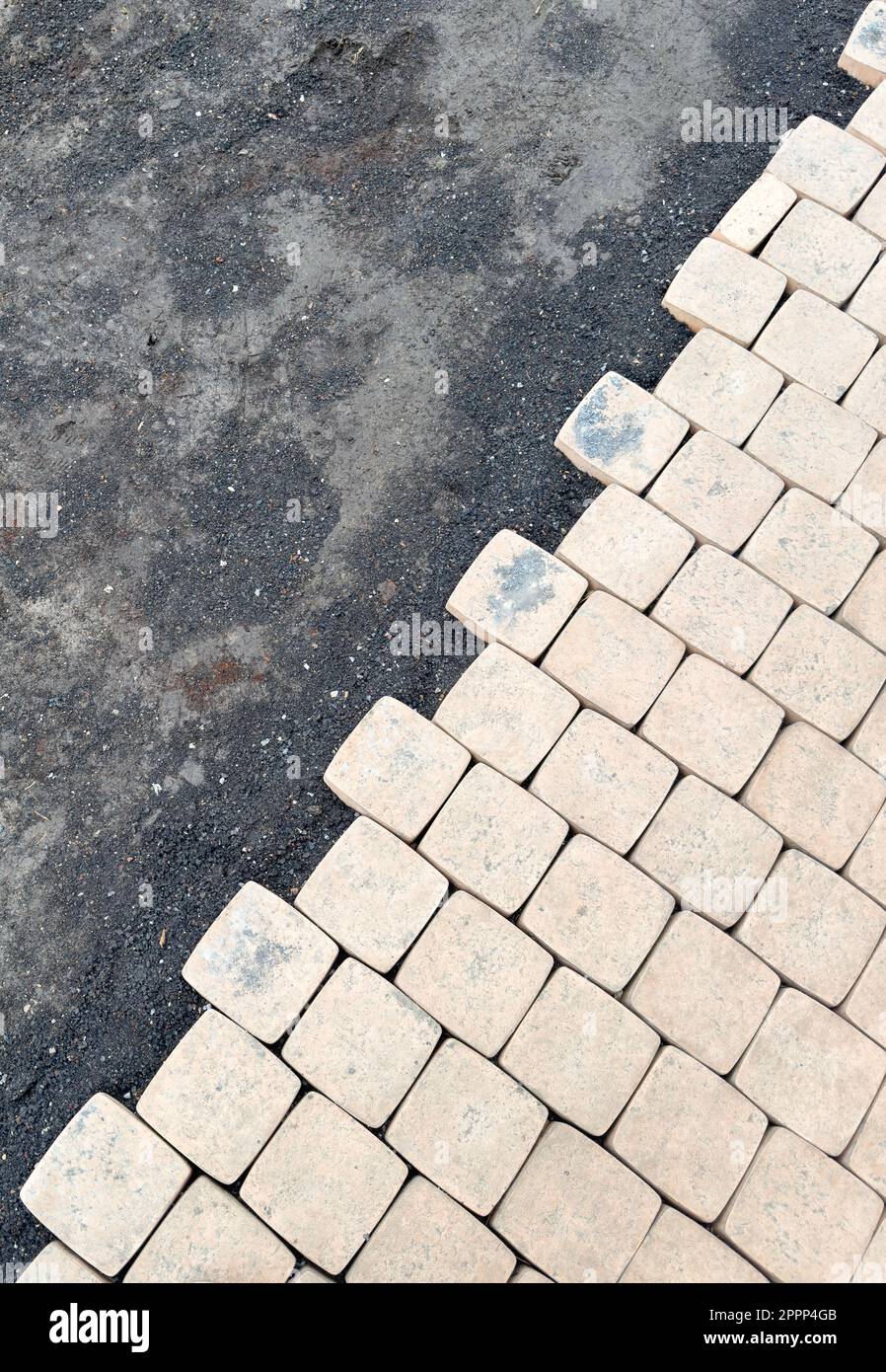 Laying yellow concrete paving slabs. Sidewalk or patio tile or slabs on