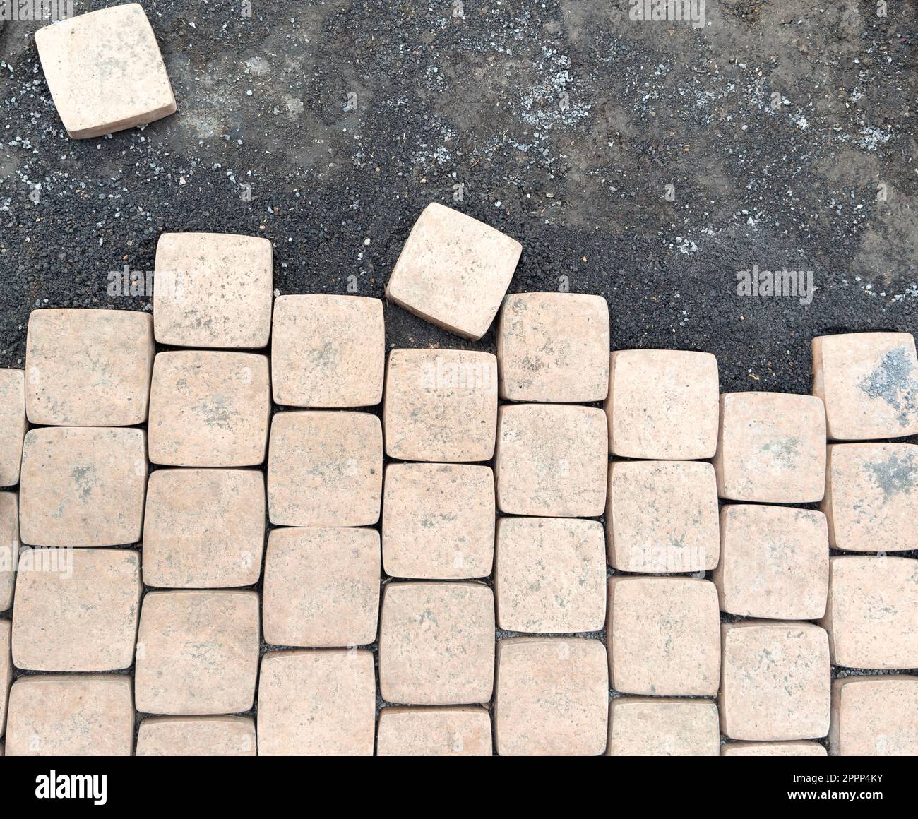 Laying yellow concrete paving slabs. Sidewalk or patio tile or slabs on