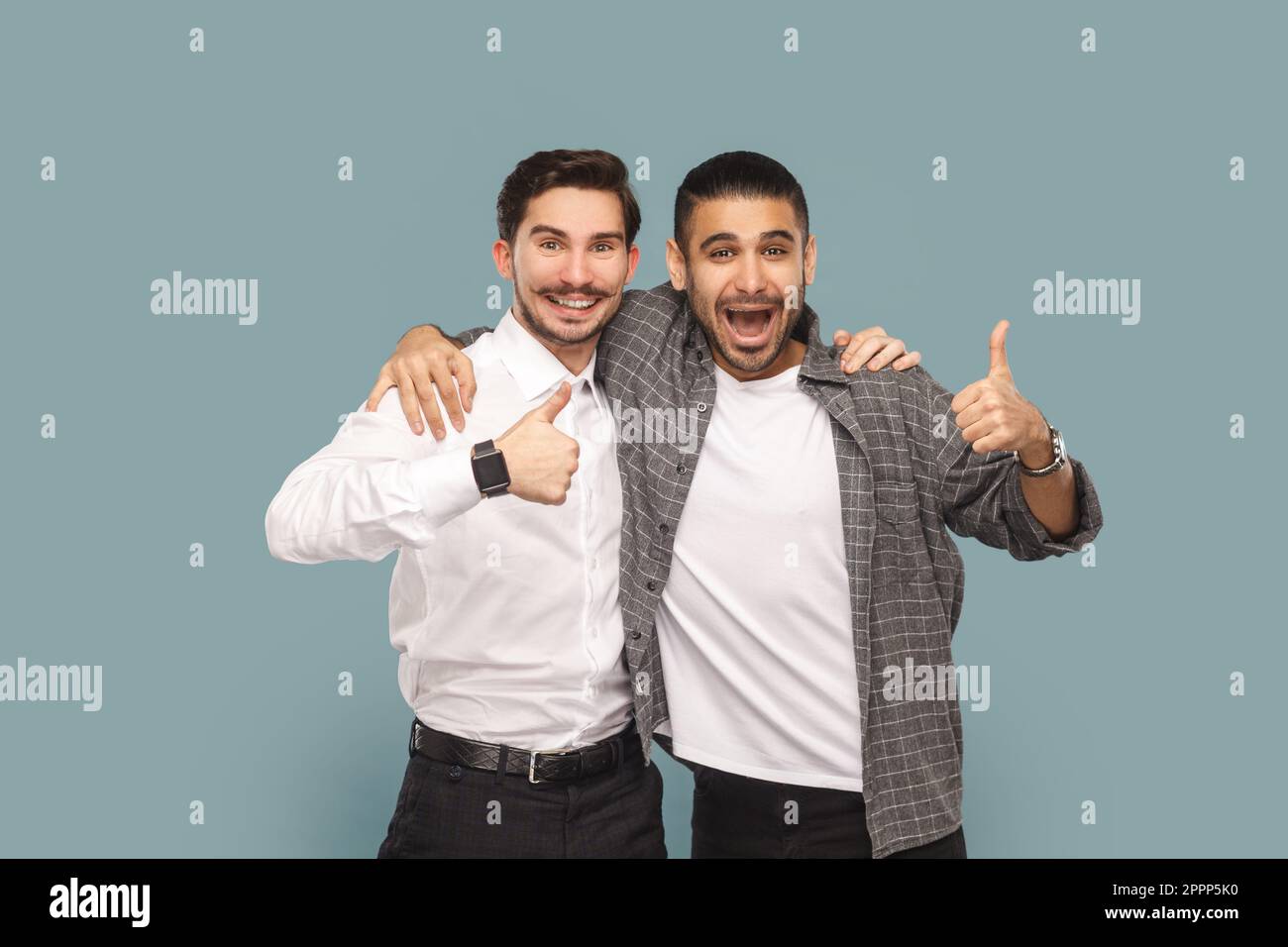 Portrait of two satisfied men friends, standing together and hugging ...