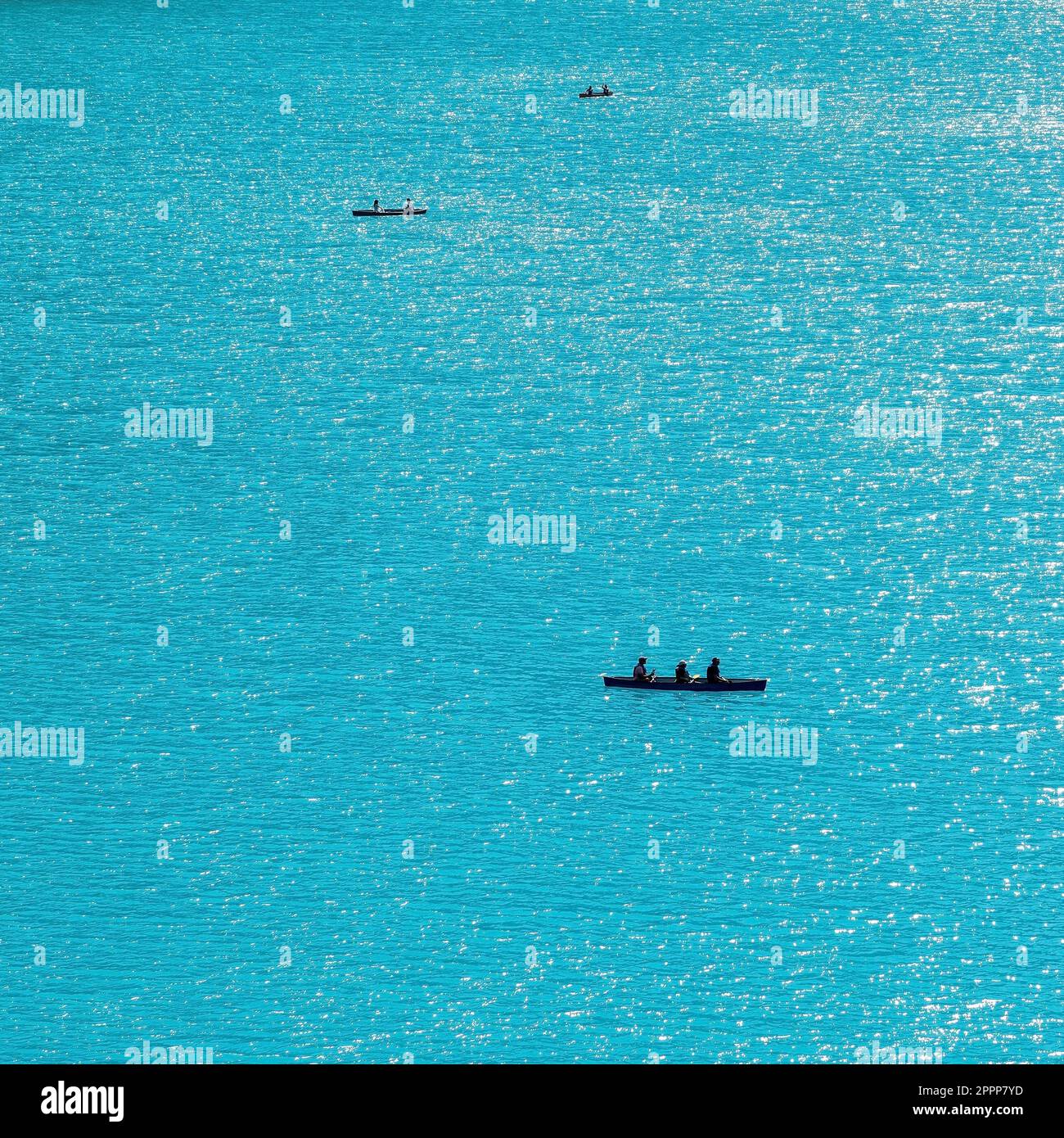 Silhouettes of people kayaking on turquoise waters of Moraine Lake, Banff national park, Canada. Stock Photo