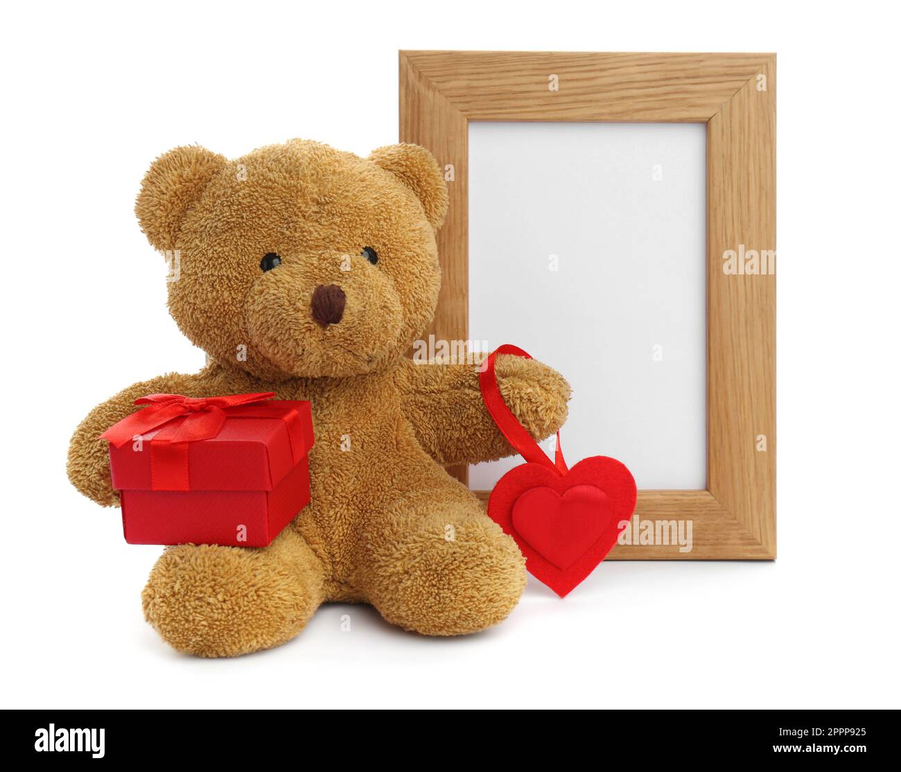 Cute teddy bear with red heart, gift box and frame on white background ...
