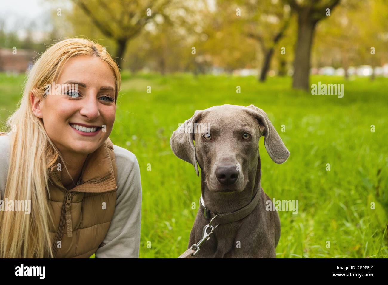 Portrait of dog and mistress outdoors in nature. Smiling girl looking