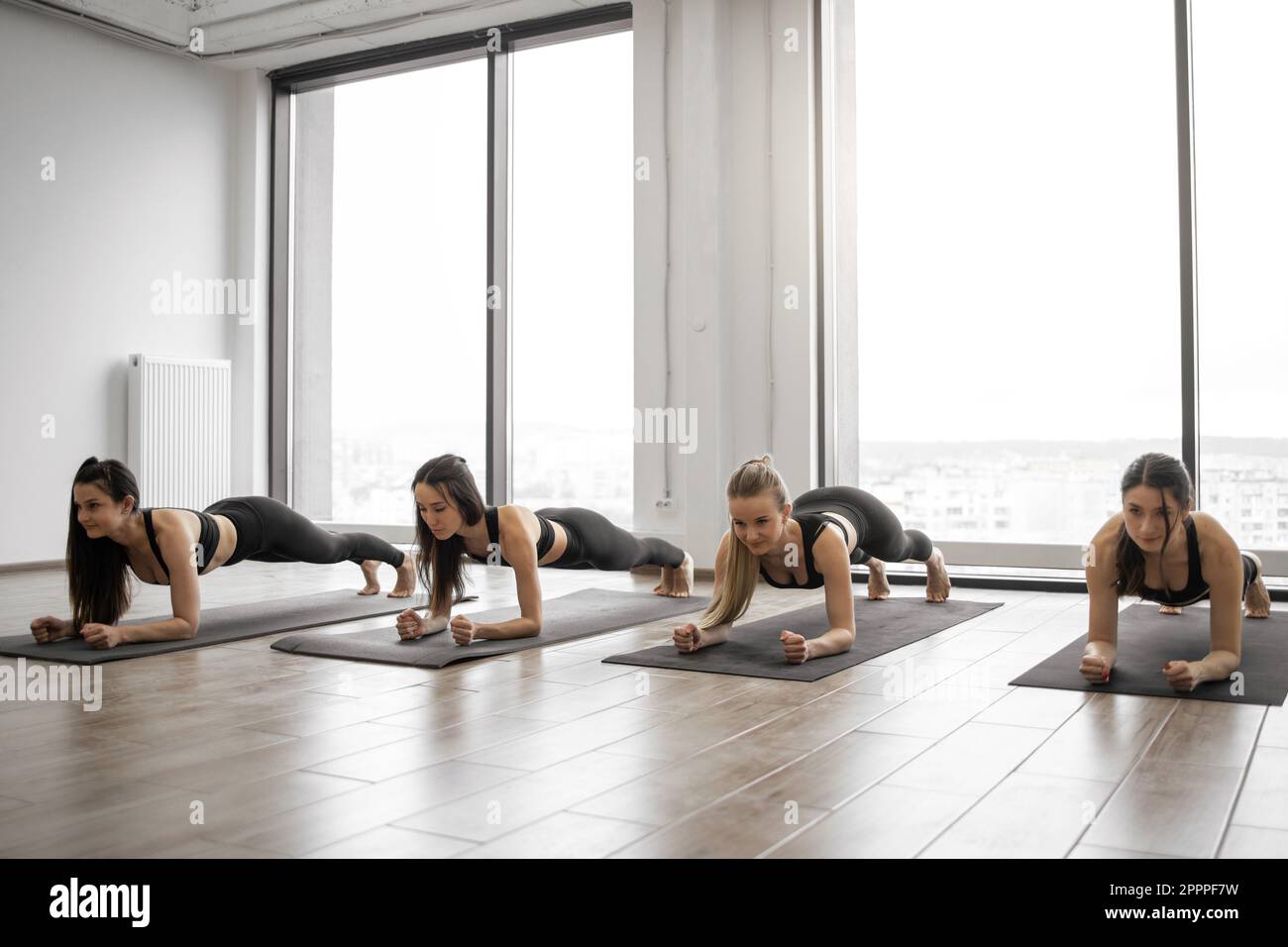 Young sporty woman practicing yoga, doing strengthening exercises