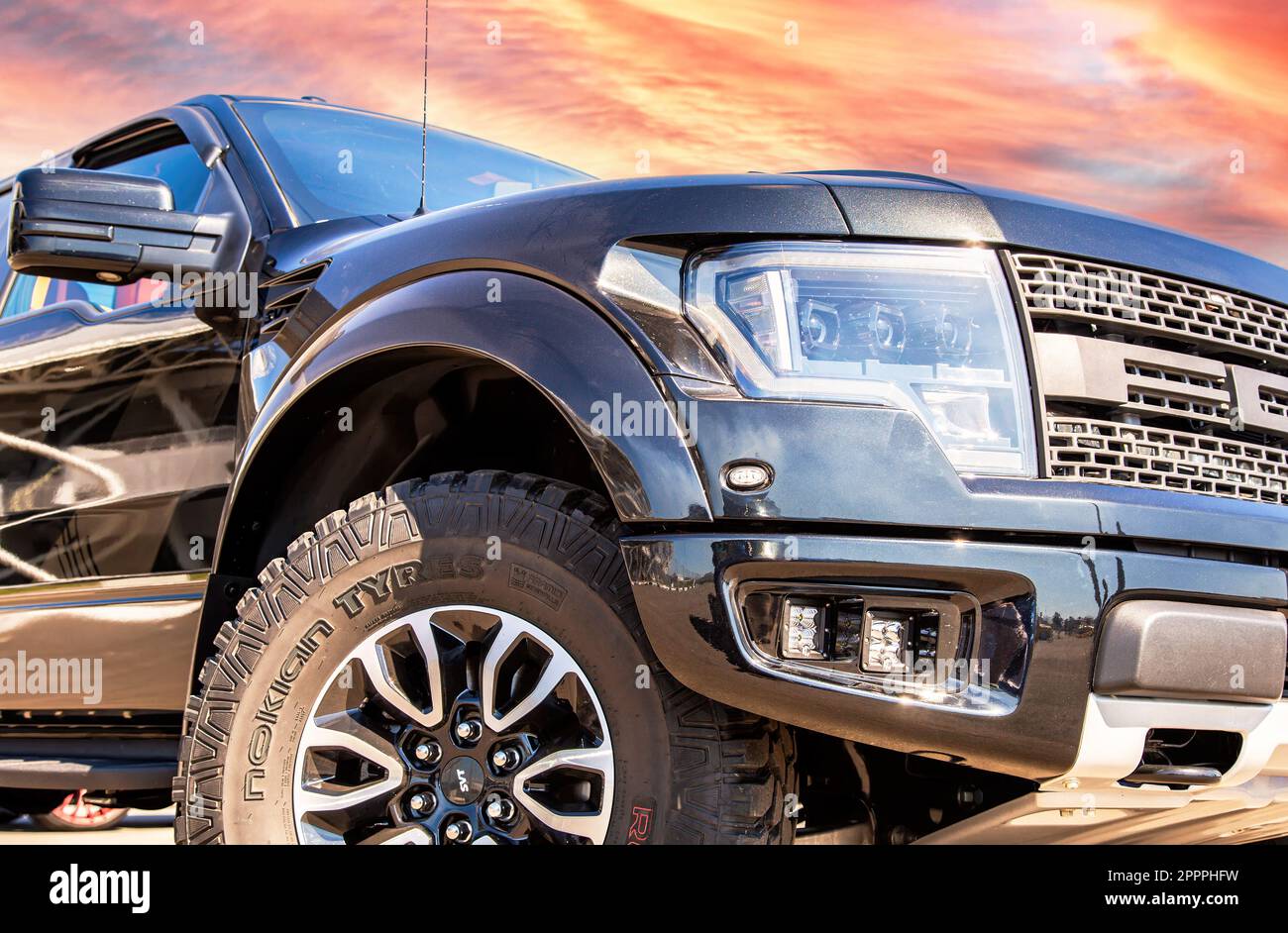 Samara, Russia - June 26, 2022: Off-road 4x4 Ford F-150 Raptor vehicle with all terrain tires Nokian Tyres against a sunset sky . Black all terrain ve Stock Photo