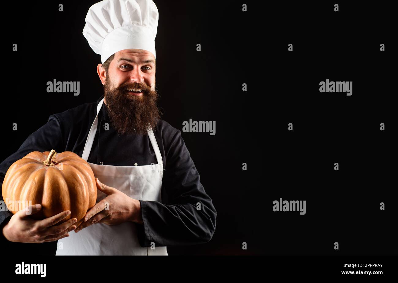 Chef in uniform with pumpkin. Bearded man in chef hat with squash. Organic food. Cook chef in white apron with pumpkin for culinary. Thanksgiving day Stock Photo