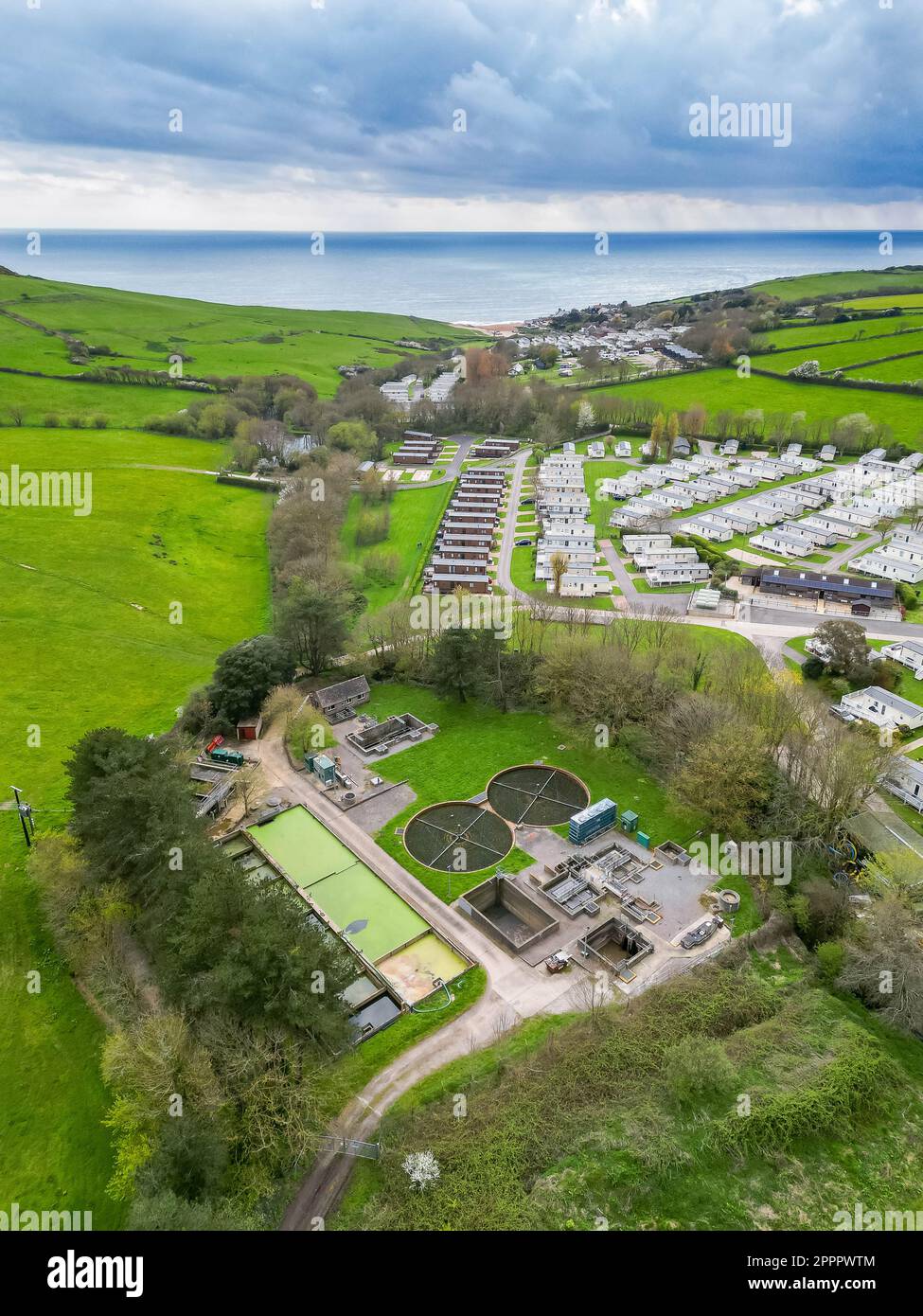 Seatown, Dorset, UK.  24th April 2023.  View from the air of the Mill Lane, Chideock sewage treatment works at Seatown in Dorset owned by Wessex Water.   In 2022, the sewer storm overflow, (Permit number: 401068) spilled 35 times for a total of 363.50 hours, discharging into the River Winniford, which is next to the sewage works.  Golden Cap Holiday Park is on the opposite bank of the river. (Source: https://theriverstrust.org/key-issues/sewage-in-rivers) Picture Credit: Graham Hunt/Alamy Live News Stock Photo