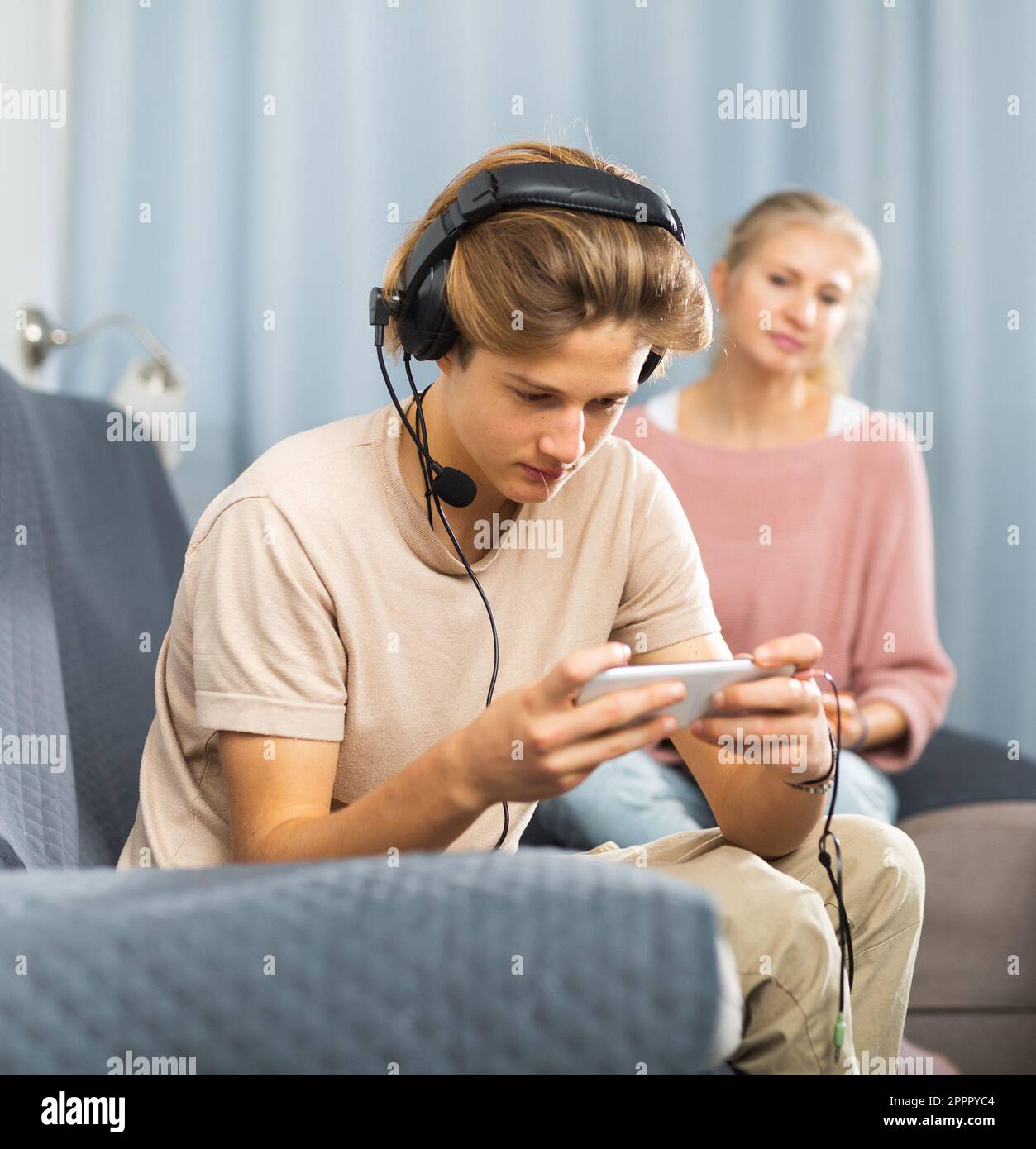 Boy playing game on phone, mother waiting him Stock Photo - Alamy