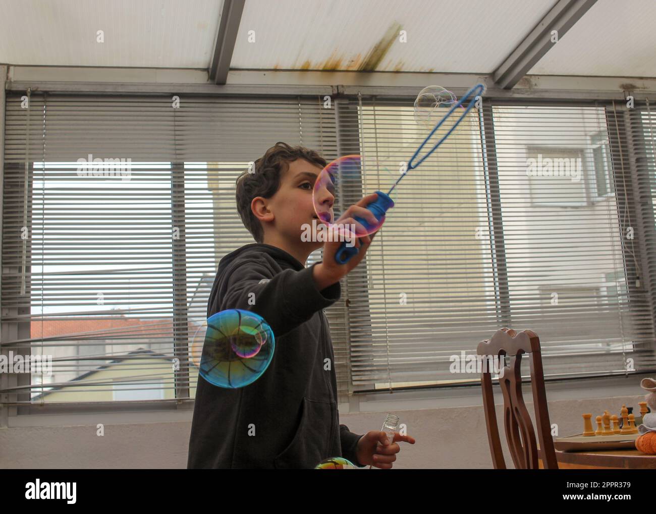 young boy having fun with bubbles at home as an alternative to
