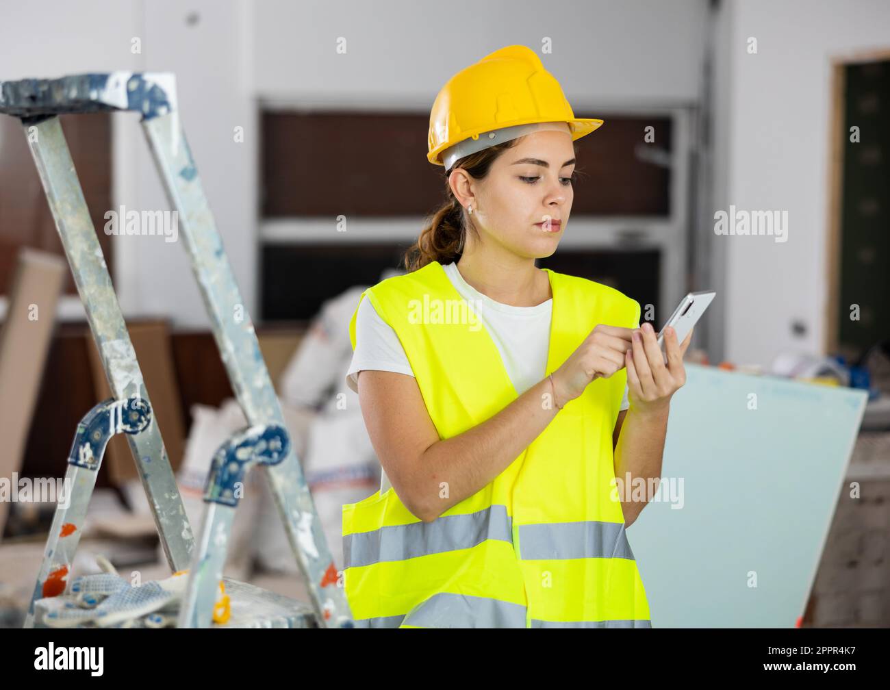 Young woman engineer using smartphone in construction site Stock Photo