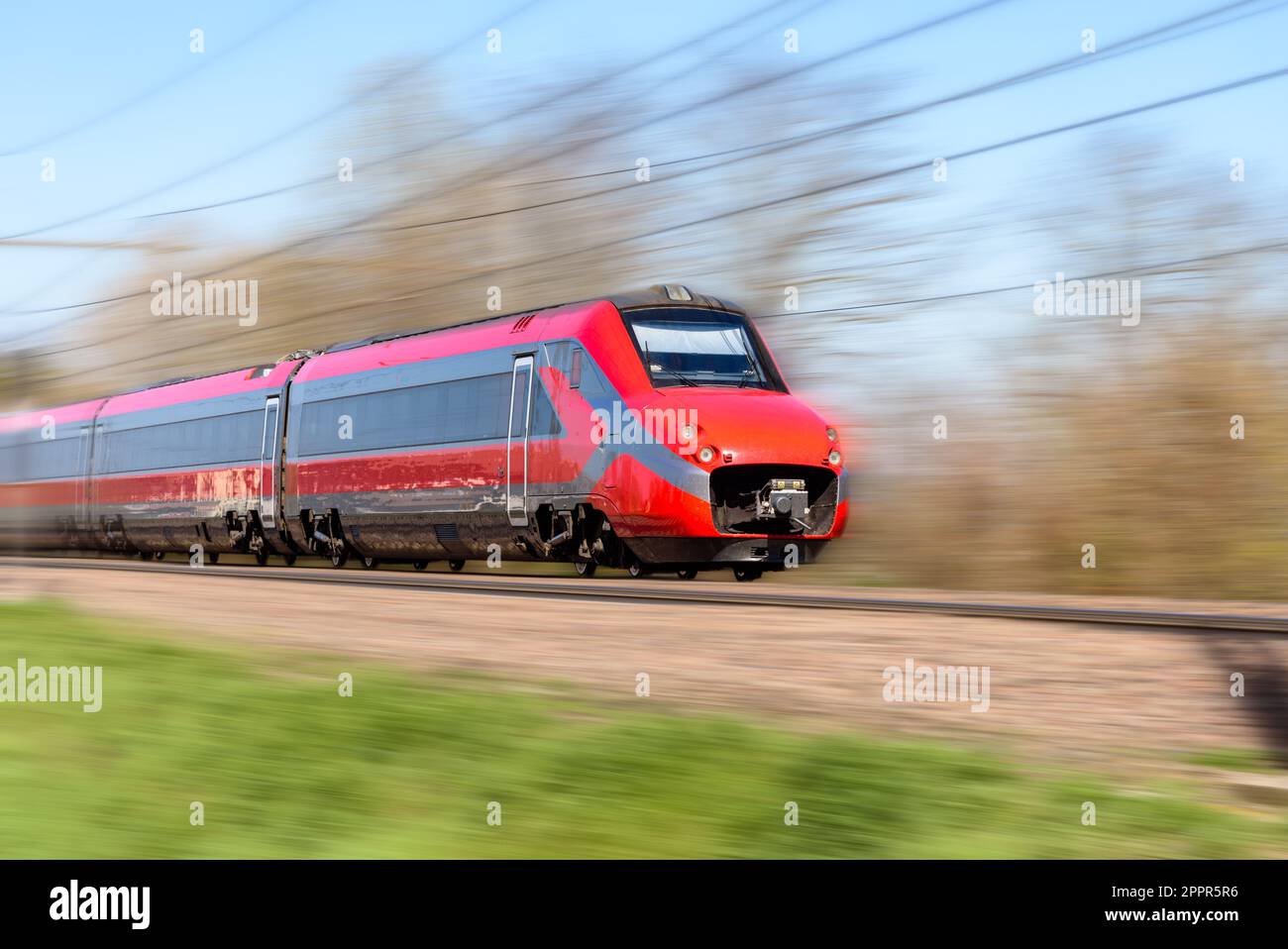 High speed train in motion in the countryside on a sunny day. Motion blur effect. Stock Photo