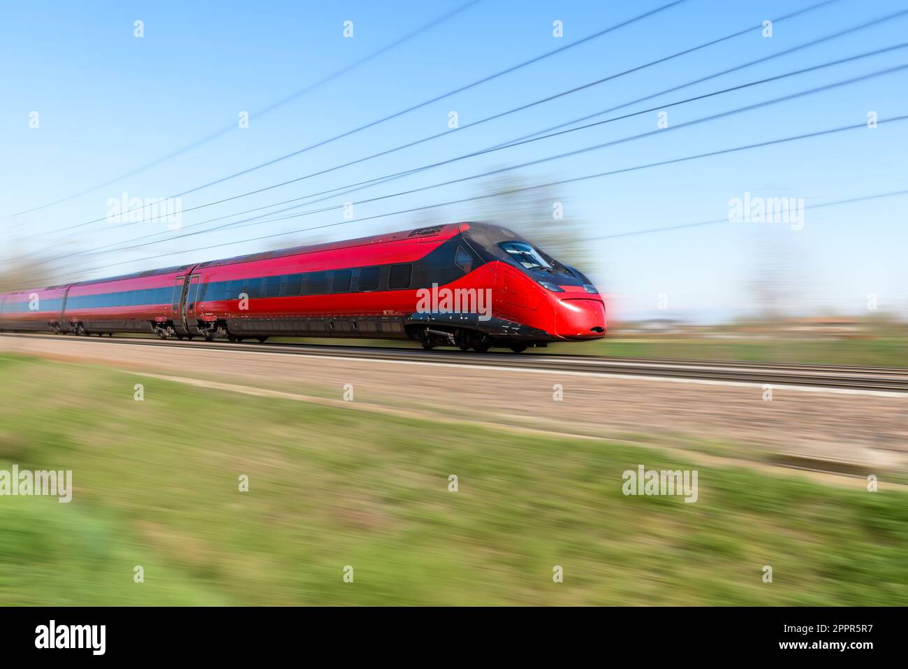Modern red high speed passenger train on a clear spring day. Motion blur effect. Stock Photo