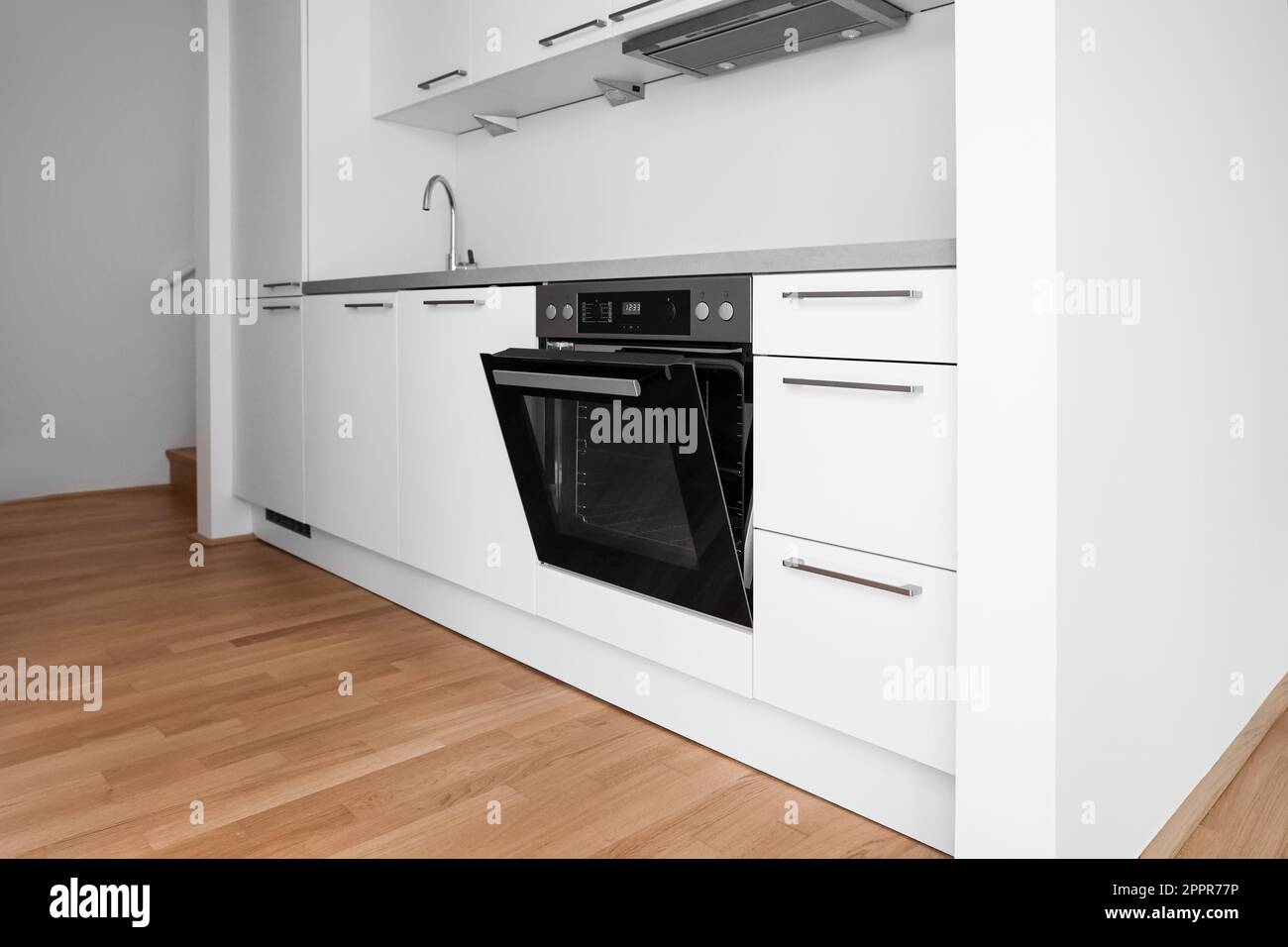 Interior of modern kitchen with white counters, sink and oven Stock ...
