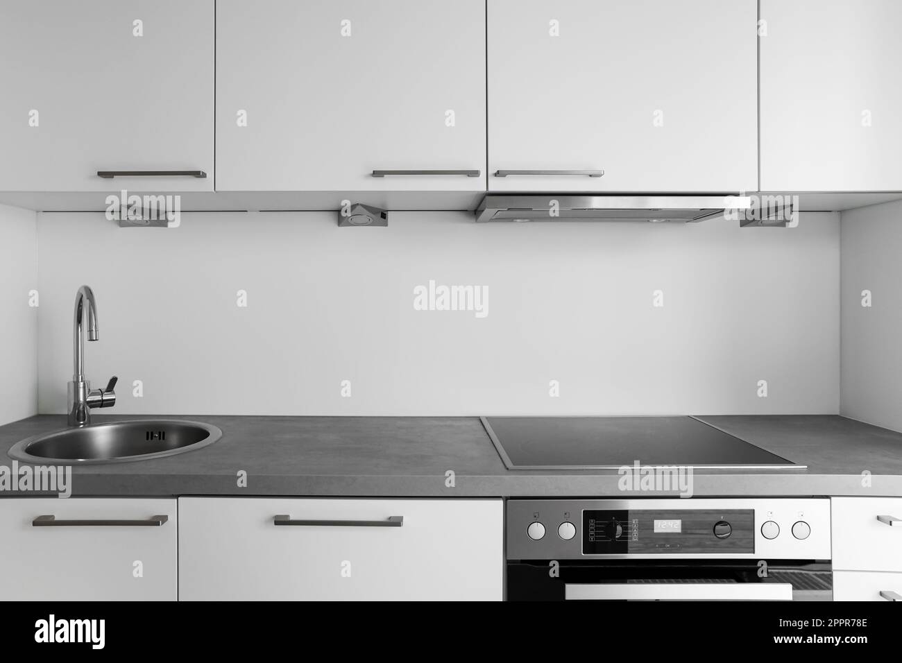 White counters with silver sink and stove in modern kitchen Stock Photo ...