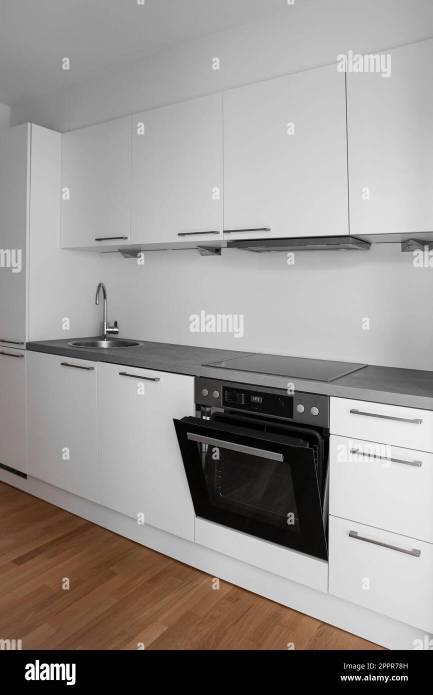 Interior of modern kitchen with white counters, sink and oven Stock ...