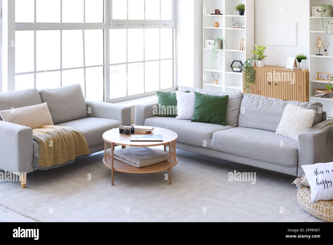 Interior of bright living room with cozy grey sofas and coffee table ...