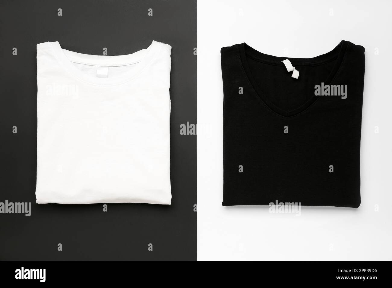 Folded black and white t-shirts on color background Stock Photo - Alamy