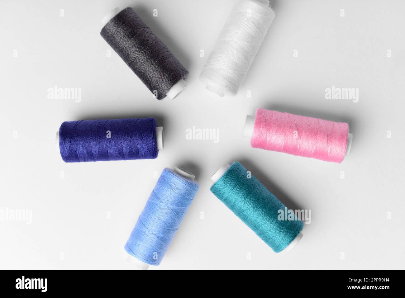 Composition with different thread spools on light background Stock Photo