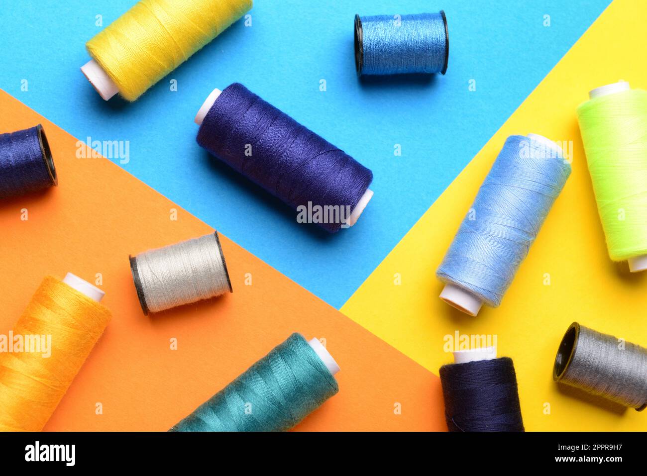 Composition with different sewing spools on color background Stock Photo