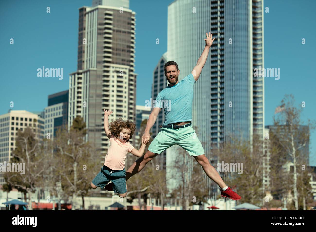 Excited father and son jumping on urban city background. Concept of ...