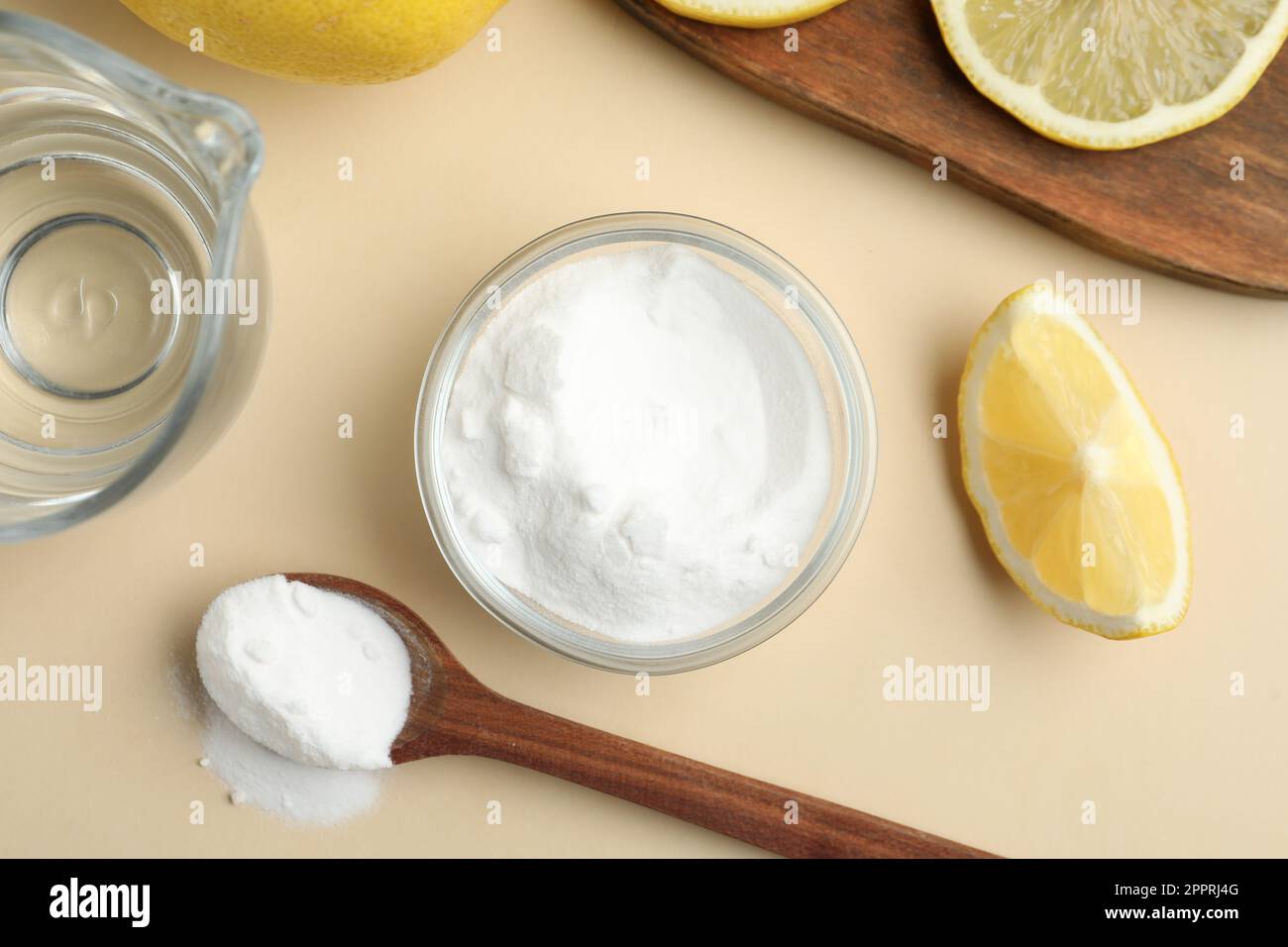 Baking soda, lemons and vinegar on beige background, flat lay Stock