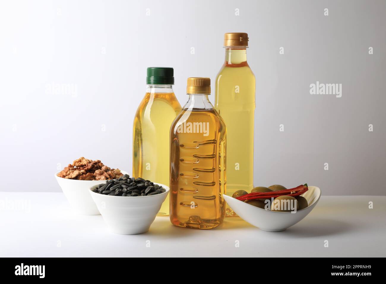 Bottles of different cooking oils, sunflower seeds, walnuts and olives