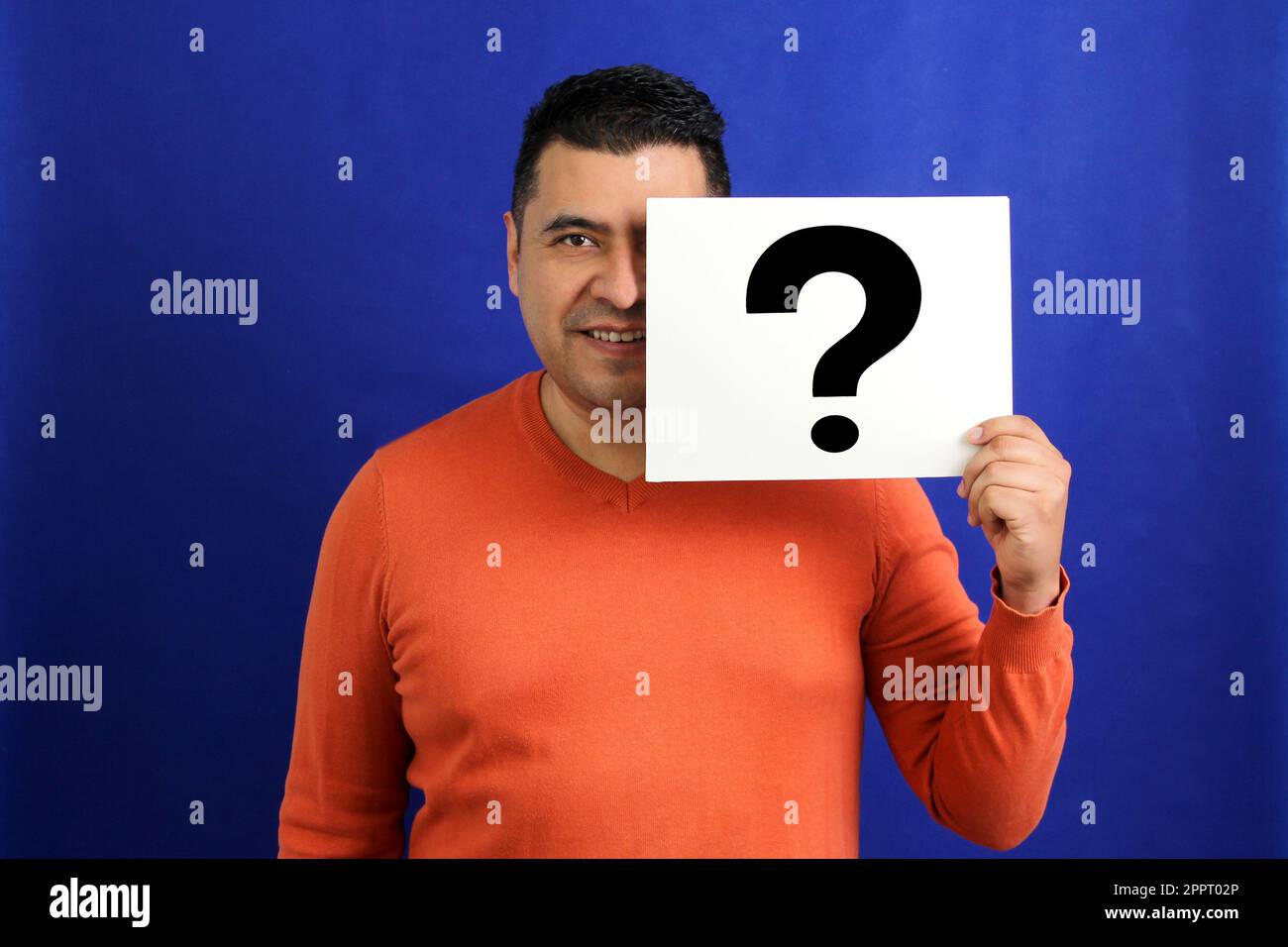 Latino brunette adult man shows a question mark, wonders, doubts, suspects, assumes, fears and distrusts Stock Photo