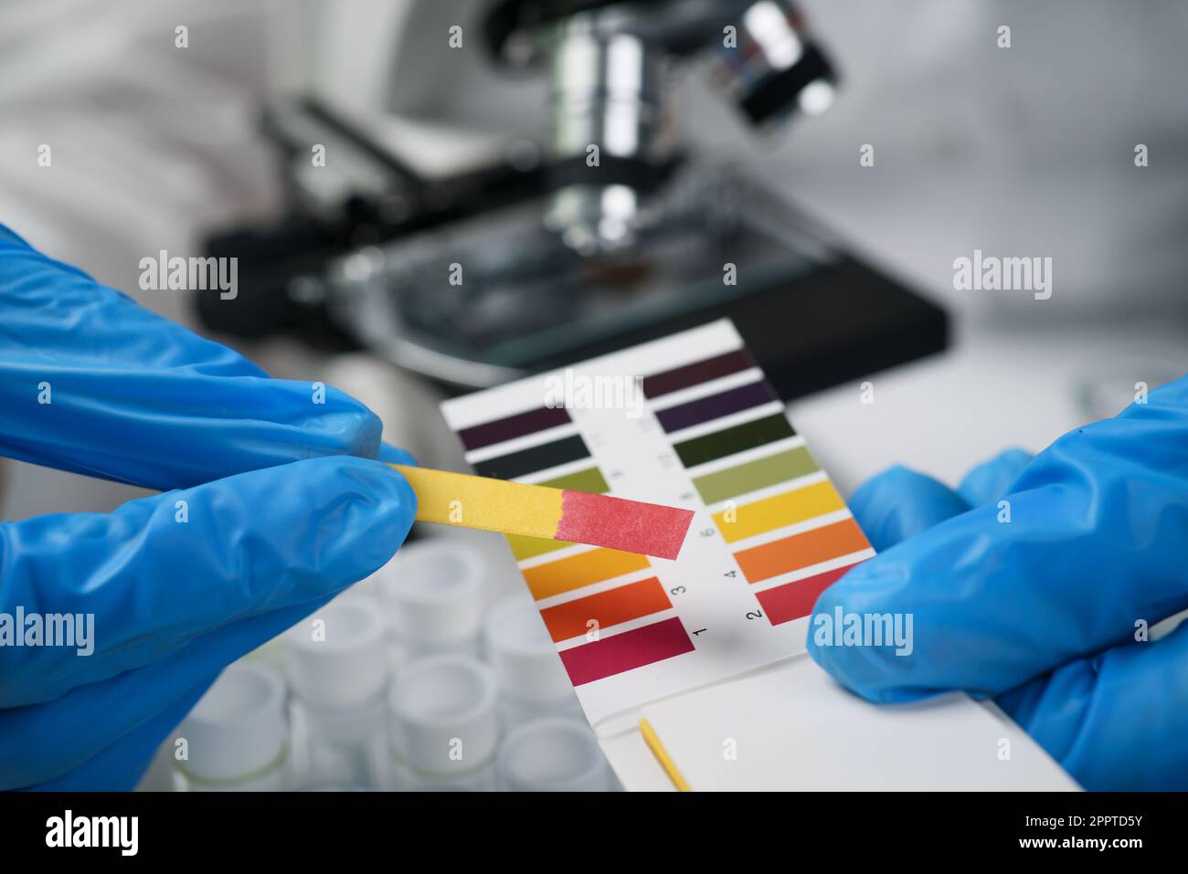 Scientist compares indicator paper to color samples palette Stock Photo
