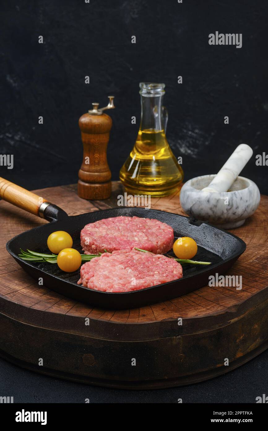 Raw beef burger patty on cast iron pan Stock Photo Alamy