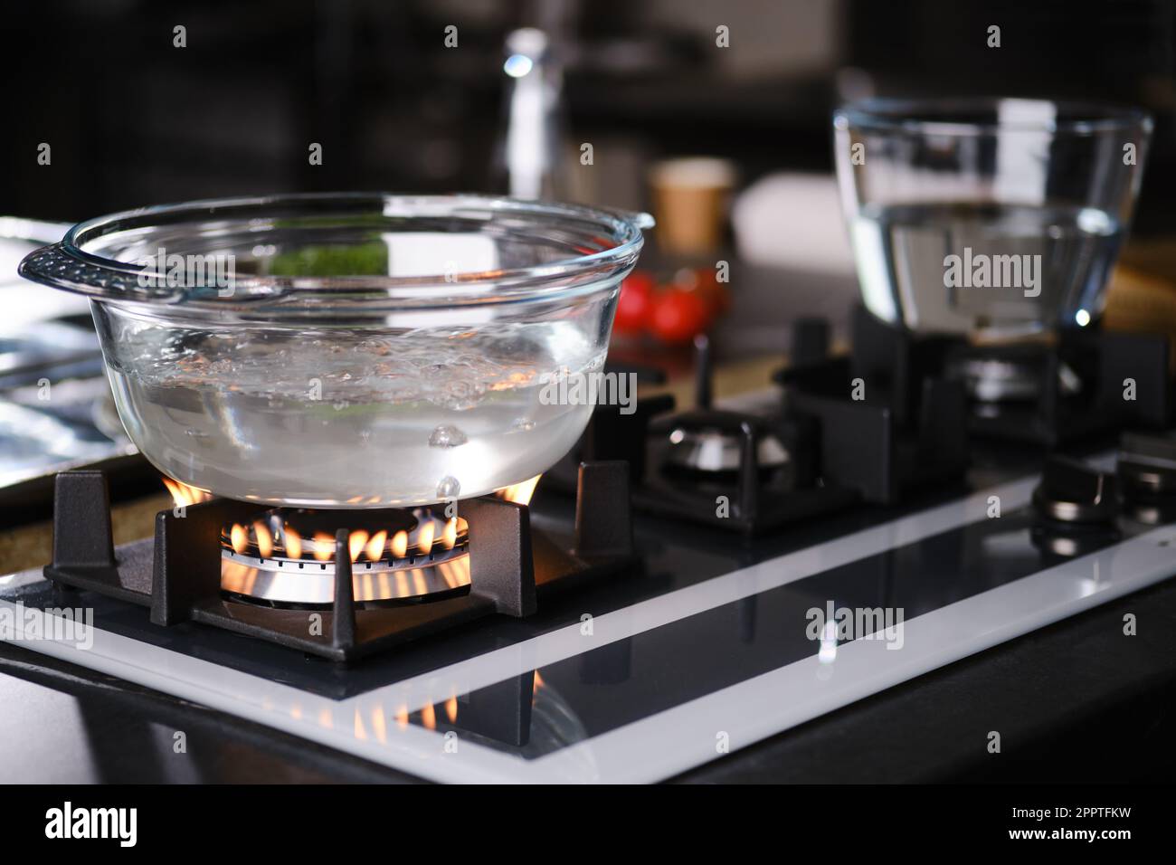 Water boiling in transparent borosilicate glass casserole on gas stove