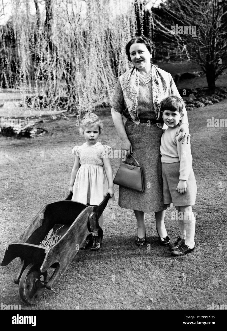 File photo dated 22/04/54 of the Royal children in this charming spring picture as Princess Anne wheels her barrow and Prince Charles cuddles up to his grandmother, the Queen Mother in the grounds of the Royal Lodge, Windsor, Berkshire. The last queen consort to be crowned was Queen Elizabeth the Queen Mother - the King's beloved grandmother - nearly 90 years ago. ssue date: Tuesday April 25, 2023. Stock Photo