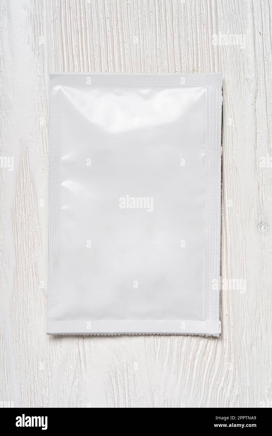 White blank paper sachet packet on wood table. Mockup template for
