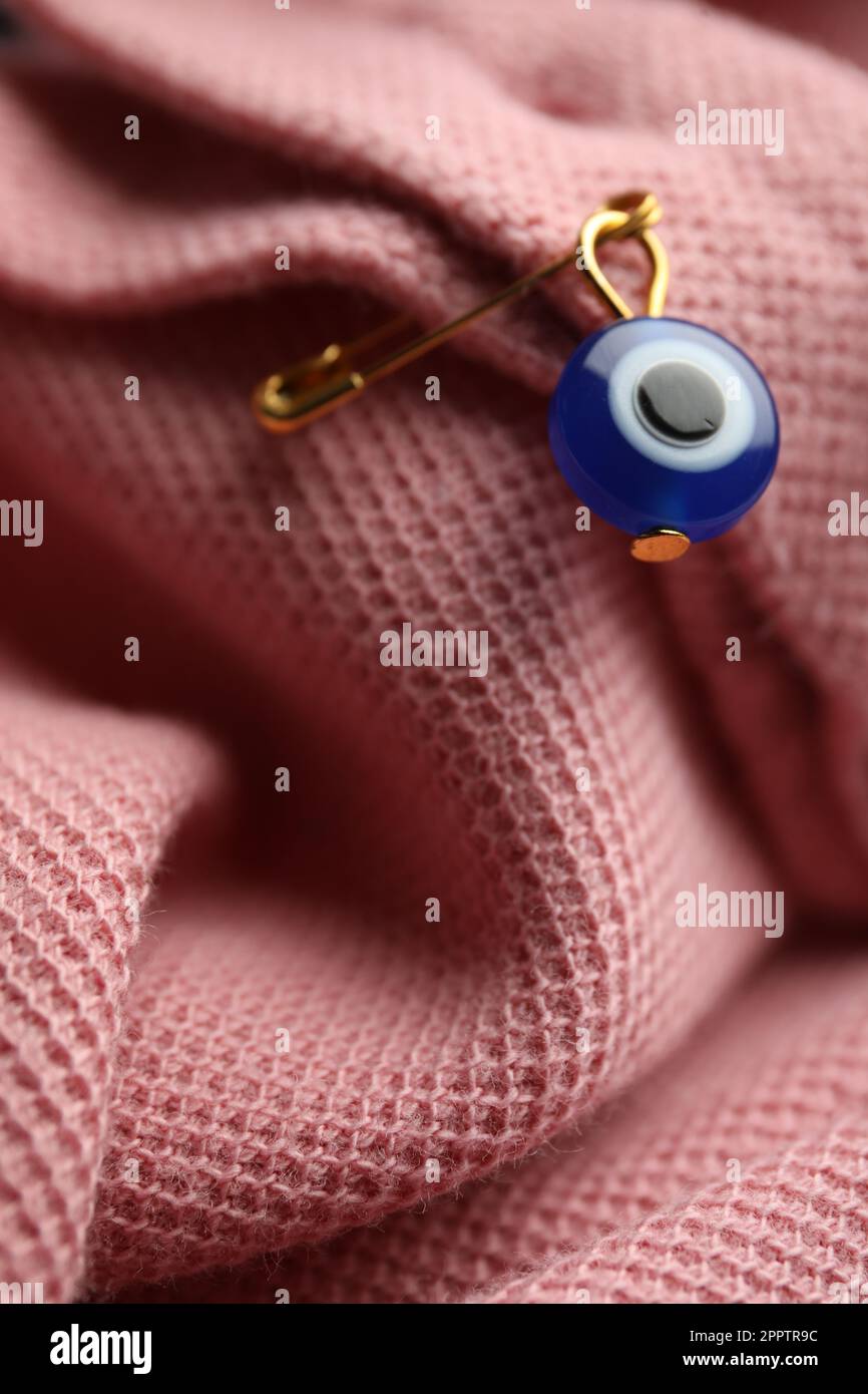 Evil eye safety pin on clothing, closeup Stock Photo - Alamy