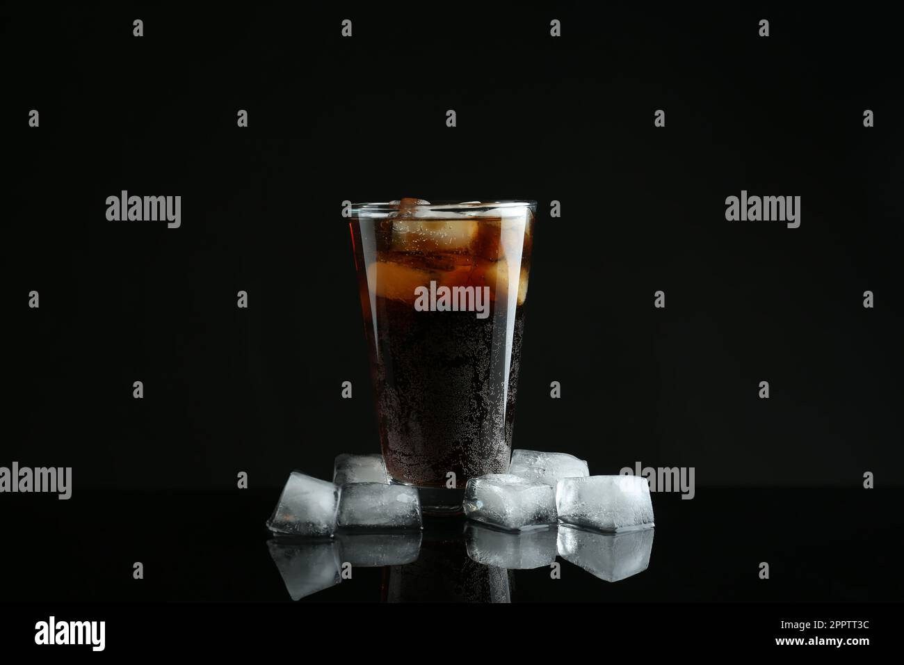 Glass of refreshing soda water with ice cubes on black background Stock ...