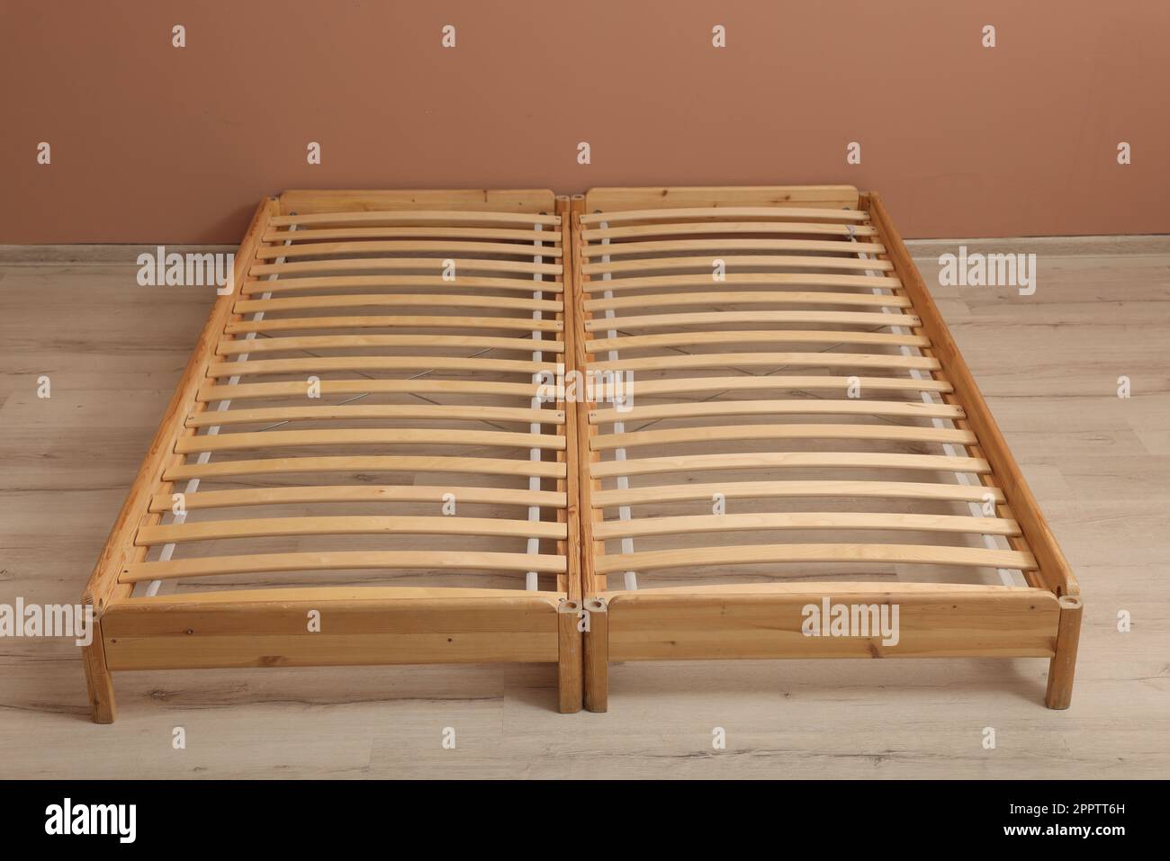Wooden bed frame on floor in room Stock Photo Alamy