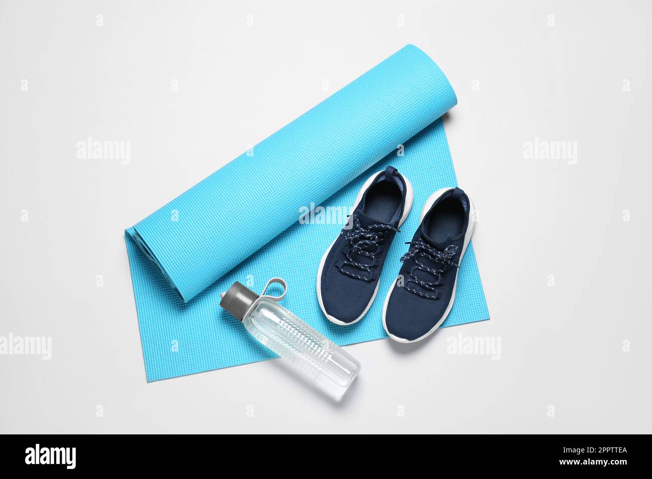 Exercise mat, bottle of water and shoes on light grey background, flat ...