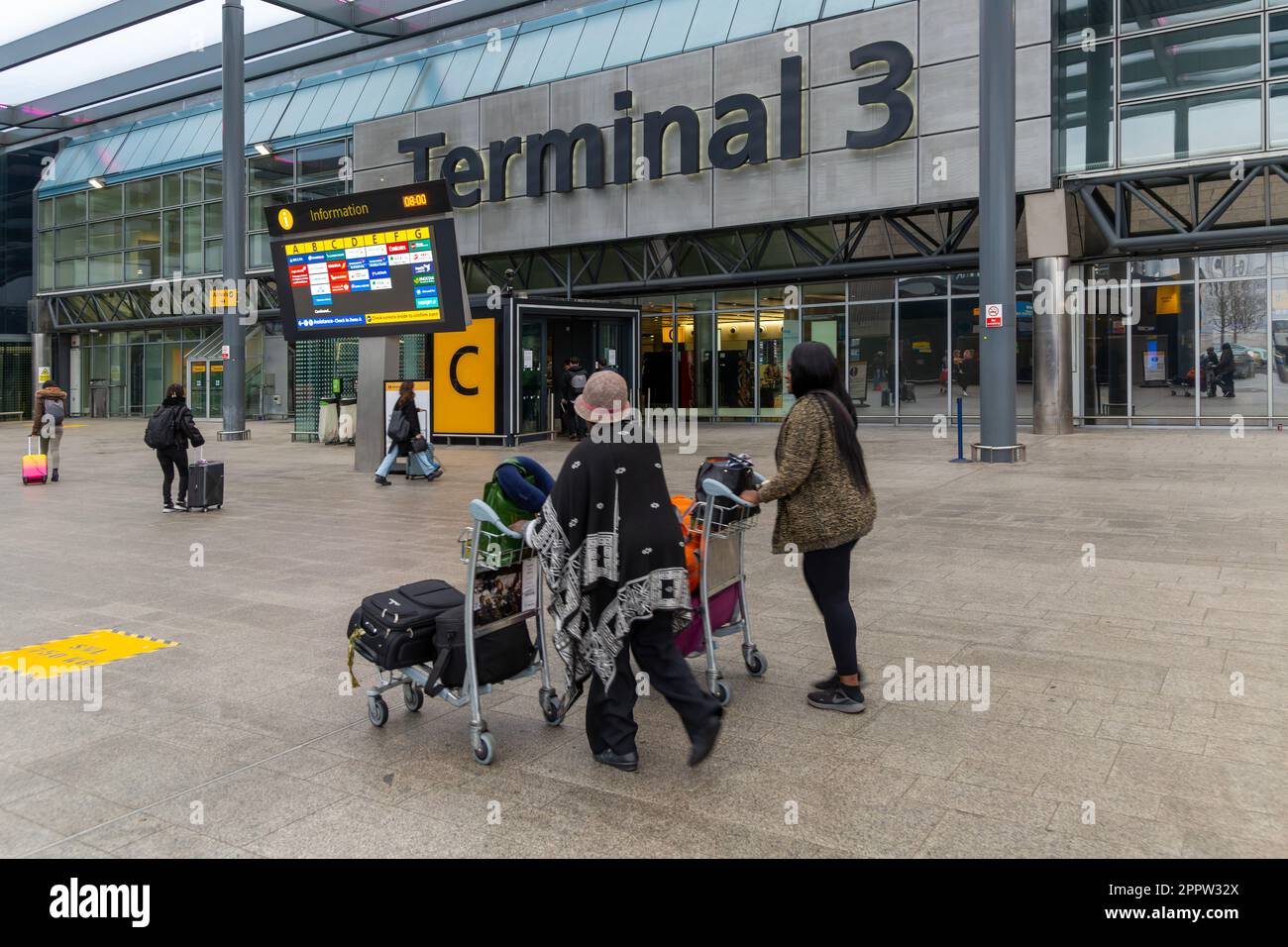 Passengers with luggage outside Terminal 3 building, London Heathrow
