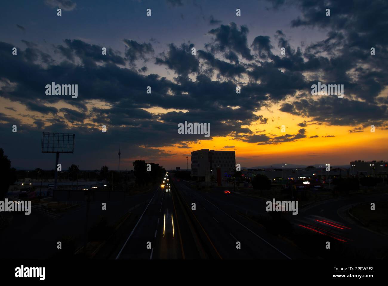 A sunset in the Queretaro city with a view of the highway and buildings Stock Photo